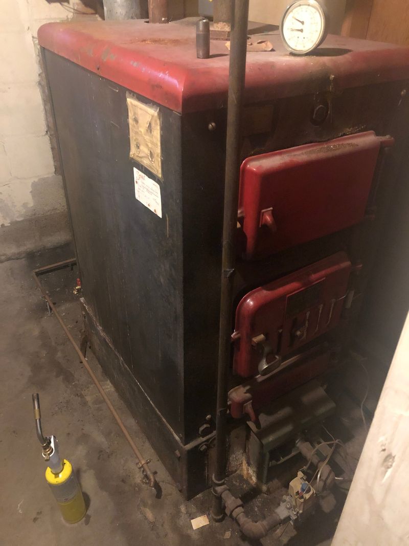 Cast-iron gas boiler in a home basement being serviced by Faith Mechanical